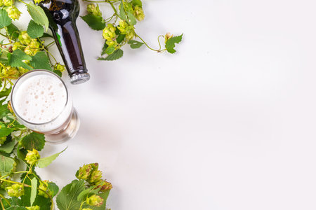Beer bottle and glass with hop cones, Fresh craft beer and ingredients, copy space on white...