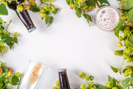 Beer bottle and glass with hop cones, Fresh craft beer and ingredients, copy space on white...