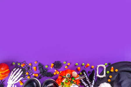 Bright colorful Halloween kids party accessories background, treat or trick holiday with colorful candies, traditional Halloween characters costumes, sweets, candy and decor top view copy spaceの写真素材