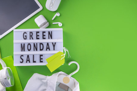 Green monday sale background with sale tags, clothes, laptop, headphones, smartphone, tablet, sale items on bright green background, flat lay top view copy spaceの写真素材