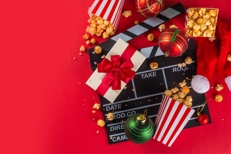 Christmas movie night part, Gather friends and family for home cinema. Invitations to New Year, Christmas movie premiere with clapperboard, Christmas tree bauble, a bucket of popcorn, Santa hatの写真素材