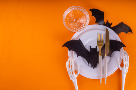 Bright Halloween table setting, with cutlery, plate and Halloween decor. Flat lay for Halloween party invitation, menu or greeting card, top view copy spaceの写真素材