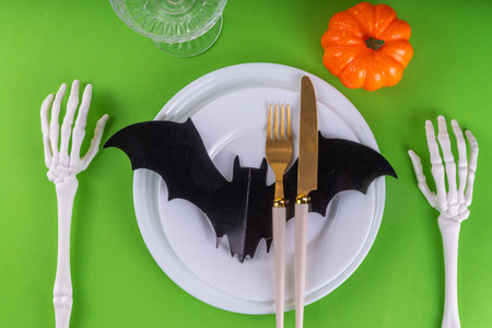 Bright Halloween table setting, with cutlery, plate and Halloween decor. Flat lay for Halloween party invitation, menu or greeting card, top view copy spaceの写真素材
