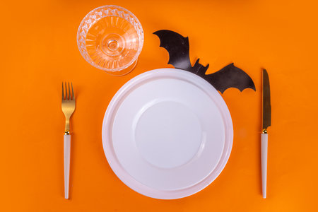 Bright Halloween table setting, with cutlery, plate and Halloween decor. Flat lay for Halloween party invitation, menu or greeting card, top view copy spaceの写真素材