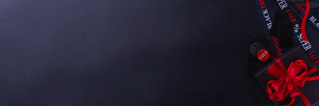 Black friday shopping and day background, Black Friday advertisement, sale promotion invitation with black red gift boxes, laptop, shop tags, crossed sale ribbons, copy spaceの写真素材