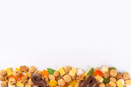 Sinterklaas, Saint Nicholas day background. Little kid red shoe with carrots and sweets, trooigoed, pepernoten, candy. Dutch Christmas holiday greeting cardの写真素材