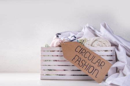 Clothing rental services background, with various woman, man, kids clothes for rent. Circular fashion, zero waste sustainable lifestyle concept, on white background with shopping tagの写真素材