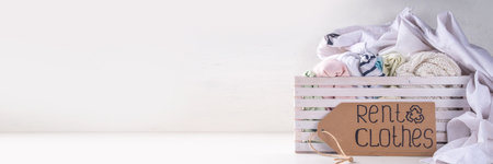 Clothing rental services background, with various woman, man, kids clothes for rent. Circular fashion, zero waste sustainable lifestyle concept, on white background with shopping tagの写真素材