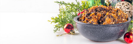 Homemade Christmas sweet mincemeat bowl, dried fruit mince meat for traditional winter mince pies with cinnamon sticks, anise, with festive decorations and christmas tree branchesの写真素材
