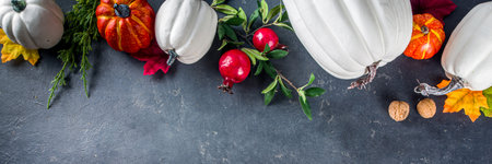 Festive thanksgiving day holiday background. White orange pumpkins, colorful autumn leaves, berries, on  dark concrete background top view frame copy spaceの写真素材