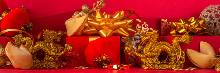 Chinese New Year 2024 greeting card. Bright red asian year of the dragon background with golden dragon figurine, Chinese lanterns, traditional jewelry, gifts, coins, cookies with wishes, copy spaceの写真素材