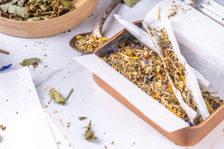 Alternative healthy berbal smoking blend. Handmade craft cigarette, preparation process, with mixture of herbs, leaves and flowers, with boxes, paper, on white backgroundの写真素材