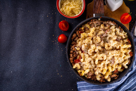 One skillet cheeseburger mac and cheese on frying pan, with macaroni pasta, a lot of cheese, bechamel sauce, ground beef meat and vegetables, tasty american food dishの写真素材