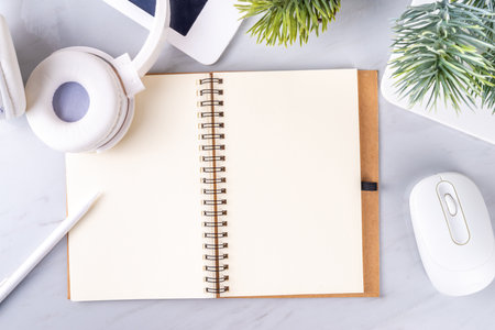 2024 goals and plans background. Blank notebook with laptop, pen, christmas tree background, on white marble office work table surface, top view copy spaceの写真素材