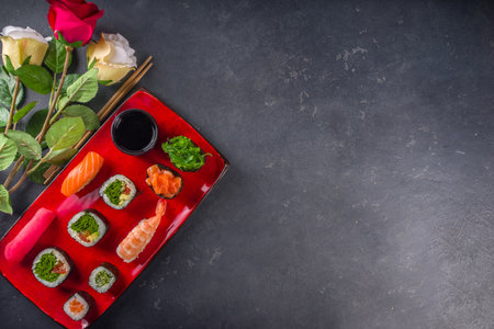 Valentine day festive dinner idea. Menu, invitation background for Valentine day sushi roll set, with heart shaped decor and rose flowers bouquet. Top view with copy space for textの写真素材