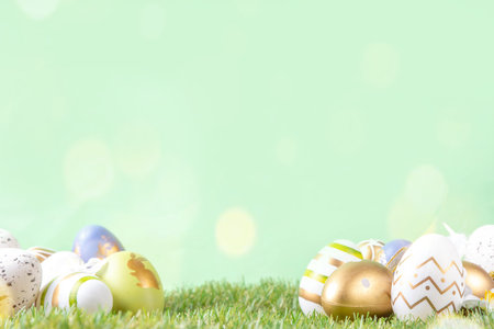 Easter egg and grass background. Funny colorful Easter eggs with bunny rabbit decor and sunny bokeh...