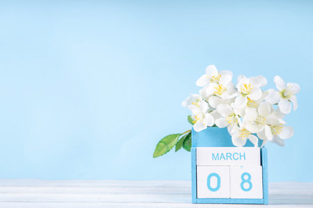 Spring holiday background with wooden calendar and spring blossom flower on light blue background copy spaceの写真素材