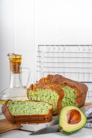 Homemade avocado loaf of bread, keto diet recipe, healthy alternative food idea, on white kitchen background with fresh avocado, copy spaceの写真素材