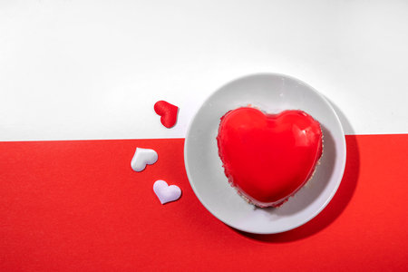 Valentine's day holiday symbol red heart portioned cake on a white-red background, top viewの写真素材