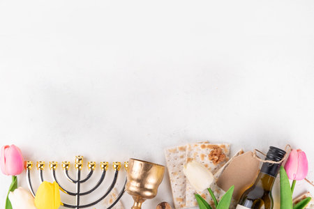 Passover celebration background. Traditional ritual Jewish bread matzah, red kosher wine, walnut, spring beautiful flowers. Jewish Easter Pesah spring holiday background copy spaceの写真素材