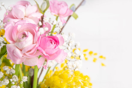 Ranunculus, willow, mimosa and gypsophila spring flowers bouquet on white background. Spring holiday...