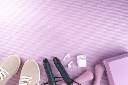 Sport and fitness, home workout plan background. Spring weight loss, slimming concept. Yoga mat and brick, dumbbells, bottle of water, headphones for sports music flat lay copy space top viewの写真素材