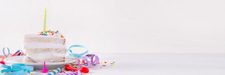 Birthday cake slice on birthday party decorated table.  Slice of Birthday Cake with white whipped cream, sugar sprinkles funfetti and candle, copy spaceの写真素材