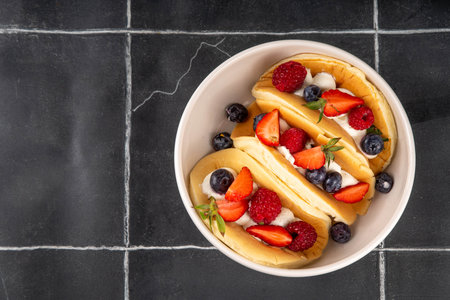 Pancake tacos. Portion of sweet dessert taco made with pancake, whipped cream, cottage cheese or ice cream, fruit and berries. Summer breakfast or brunch recipe, copy spaceの写真素材