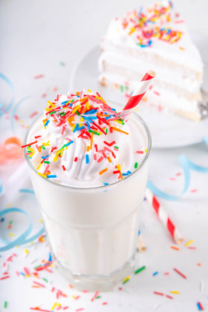 Birthday cake milkshake or smoothie drink.  Frozen homemade Birthday cake white vanilla ice cream floating cocktail with whipped cream, and colorful sugar sprinkles, funfettiの写真素材
