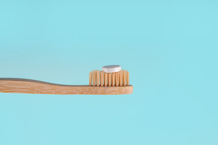 Toothpaste pills tablets on toothbrush, white solid toothpaste tablet with bamboo toothbrush on modern white bathroom backgroundの写真素材
