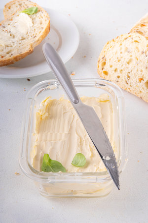 Homemade Vegan Butter, non-dairy creamy, plant based alternative butter with soy bean leave, and home baked bread on kitchen white table backgroundの写真素材