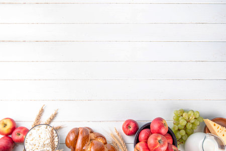 Happy Shavuot holiday background with summer red apples, wheat, grapes, dairy products - cheese, cottage cheese, milk or cream, copy space for textの写真素材