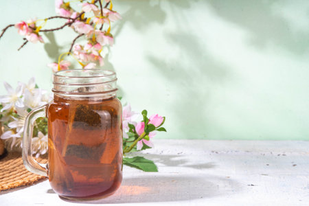 Sun Tea in mason jar, trendy cold sweet sun brew tea drink on wooden tableの写真素材