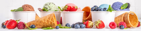 Colorful bright ice cream on bowls, with waffle cones and berries, on white background. Variety of...