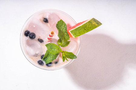 Watermelon boba balls bubble tea cocktail. Refreshing milky non-dairy milkshake cocktail with boba balls and watermelon slices on background. Summer garnished sweet dessert iced drinkの写真素材