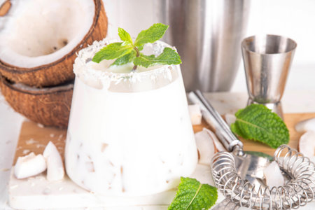 Coconut mint margarita cocktail. Homemade summer cold refreshing coconut milk Lime Margarita with...