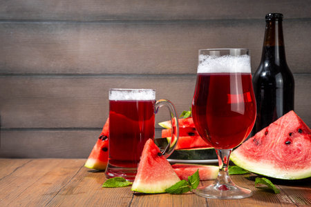 Glasses with tasty Sweet fruit berry watermelon Craft Beer, Cider or Ale on wooden table with fresh  watermelon slicesの写真素材