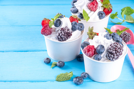 Frozen yogurt dessert with various berry toppings. Whipped creamy yoghurt ice cream with raspberry,...