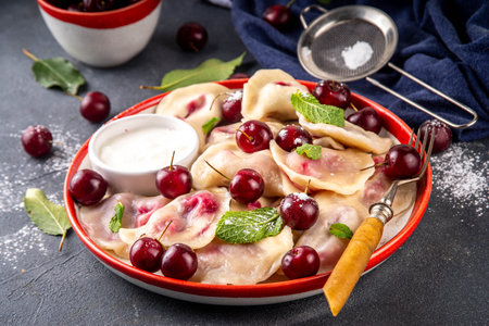 Traditional West Europe Dumplings with Cherries, ukrainian, polish vegan Cherry Pierogi, Sweet berry fruit Vareniki, ravioli with sour cream and sugar powderの写真素材
