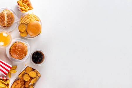Fast food delivery menu background with various burgers, cheeseburger, nuggets, french fries, fizzy soda drinks. Junk unhealthy fast food, Ultra processed food with low nutrition, high calories valueの写真素材