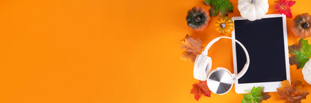 Autumn Thanksgiving holiday, sale, invitation background, tablet with autumn fall leaves, pumpkins and headphones, Fall vibes and cozy music concept, flat lay copy spaceの写真素材