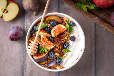 Healthy autumn breakfast bowl. Cottage cheese or yogurt with granola, nuts and fall seasonal fruits,balanced comfort food snack for morning and lunch, copy spaceの写真素材