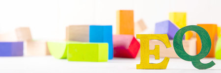 Kids EQ, child emotional quotient concept with wooden cubes children toys on background, wooden...
