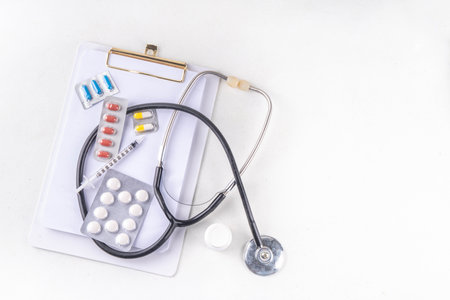 Simple medical healthcare background with notebook, clipboard, stethoscope, syringe and pills, Doctors, tests, health care, annual vaccination background top view copy spaceの写真素材