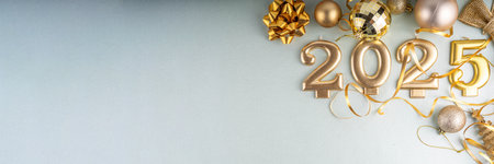 Merry Christmas and Happy New Year 2025 background with golden bauble, Christmas tree balls and decorations, gift bow, serpentine, 2025 golden candles numbers, flat lay top view copy spaceの写真素材