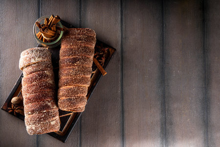 Traditional East Europe Christmas sugar glazed dessert chimney cake, trdlo or trdelnik, sweet aromatic winter seasonal street food with cinnamon and spicesの写真素材