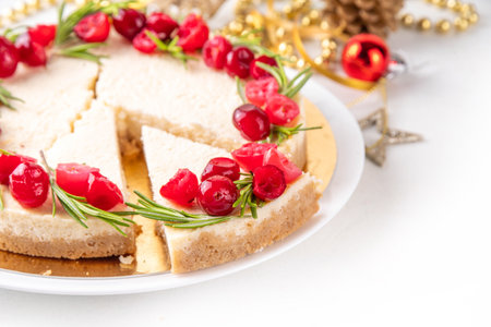 Tasty Christmas cheesecake with cranberries and rosemary decorated like Christmas wreath. Simple elegant winter white dessertの写真素材