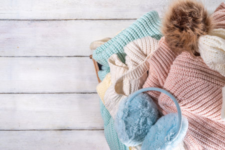 Preparation for fall and winter season, autumn warm cozy clothes, Stack of clean freshly laundered, neatly folded jackets, sweaters, blankets, hats, mittens in wooden box, taken from the mezzanineの写真素材