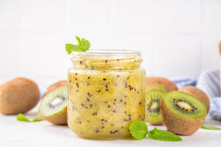 Homemade tasty sweet sour Kiwi Jam marmalade in small jar with Fresh Kiwi Fruits on white tableの写真素材