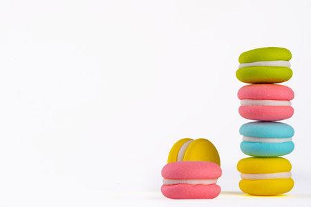Bright colored macaroon cookies on white background, multicolor sweets dessert backgroundの写真素材